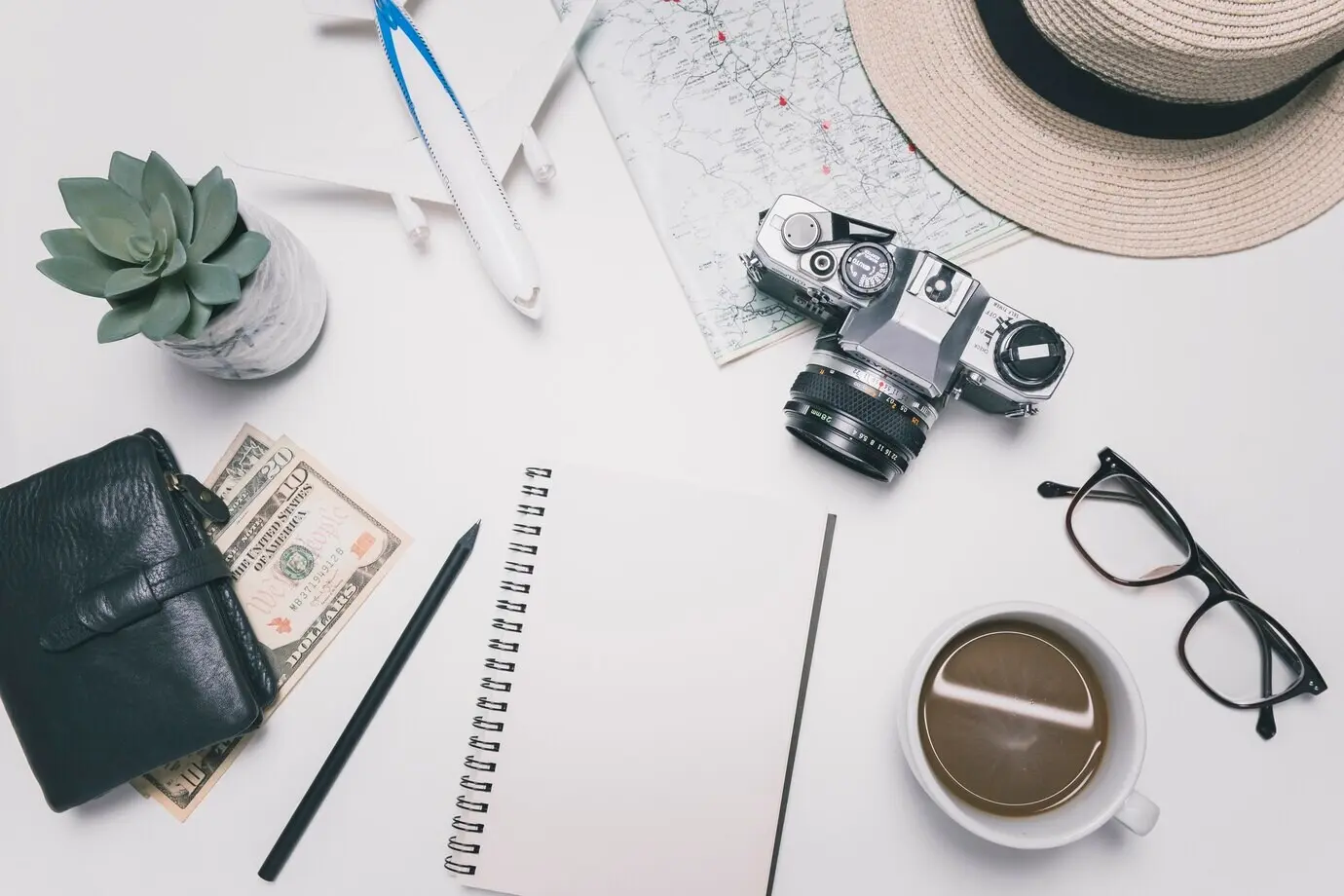 Blank notebook beside travel supplies
