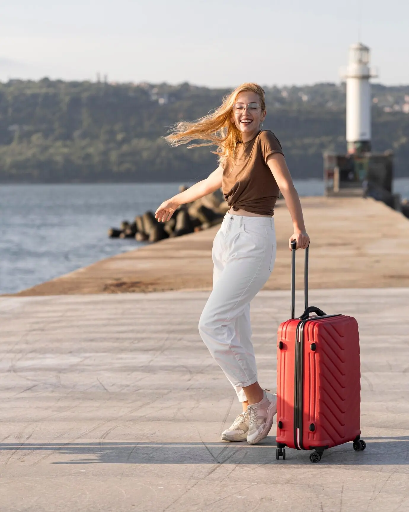 A full shot of a happy woman at the seaside.