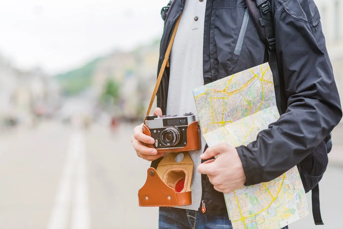 A traveler on a street with a map and a camera.